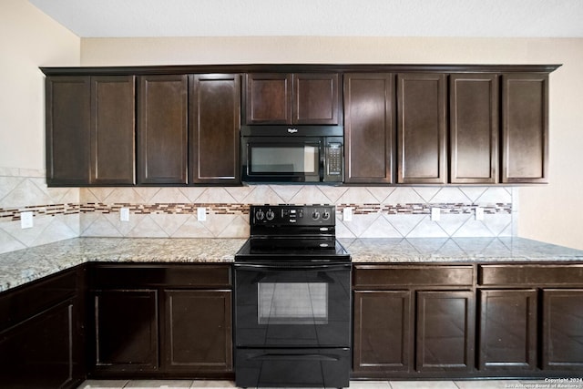 kitchen featuring light stone counters, dark brown cabinets, and black appliances