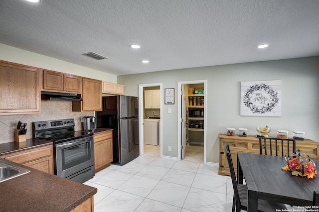 kitchen featuring washer / clothes dryer, decorative backsplash, a textured ceiling, and appliances with stainless steel finishes