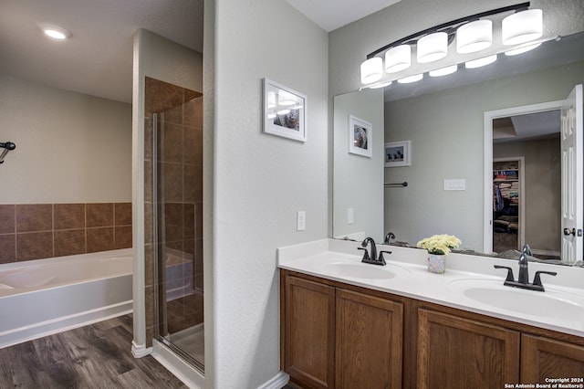 bathroom featuring vanity, wood-type flooring, and plus walk in shower