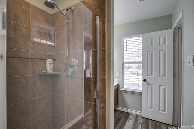 bathroom featuring wood-type flooring and a shower with door