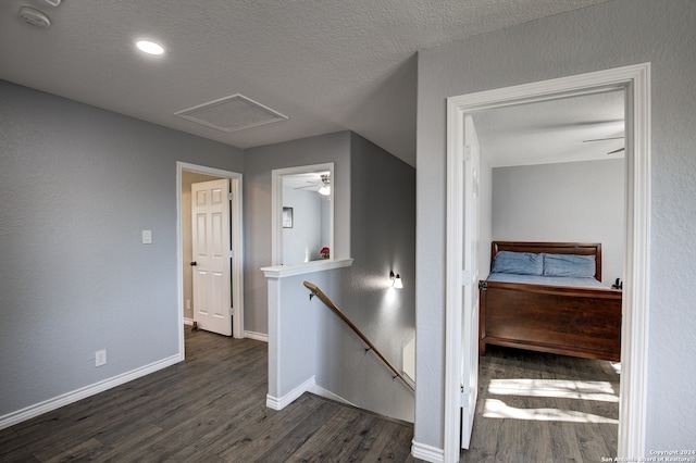 hallway with dark wood-type flooring and a textured ceiling