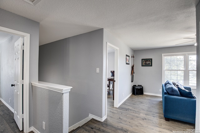 corridor featuring a textured ceiling and hardwood / wood-style flooring