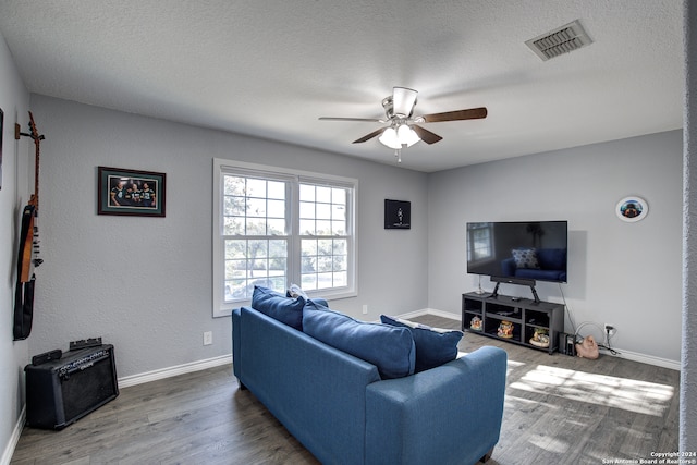 living room featuring hardwood / wood-style floors, a textured ceiling, and ceiling fan