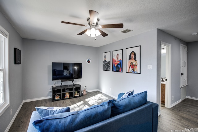 living room featuring a textured ceiling, dark hardwood / wood-style flooring, and ceiling fan