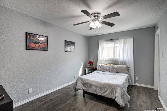 bedroom with ceiling fan, dark hardwood / wood-style flooring, and a textured ceiling