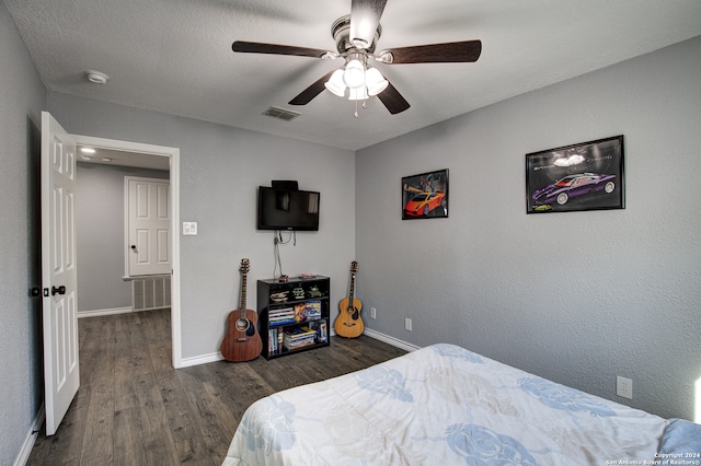 bedroom featuring ceiling fan, dark hardwood / wood-style floors, and a textured ceiling