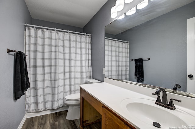 bathroom with curtained shower, toilet, vanity, and hardwood / wood-style flooring