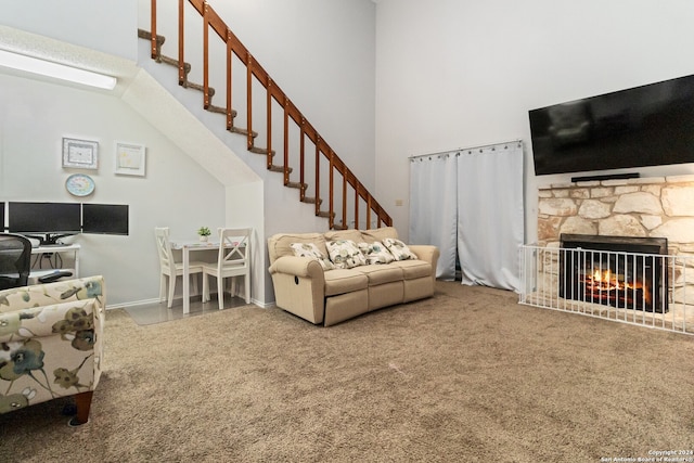 carpeted living room featuring a stone fireplace