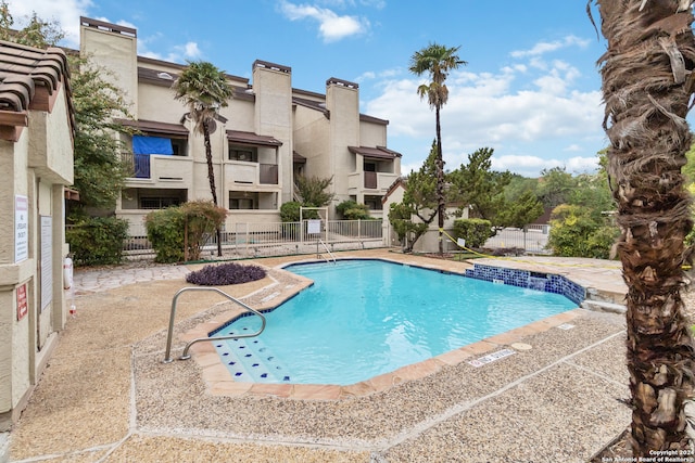 view of swimming pool featuring pool water feature and a patio area