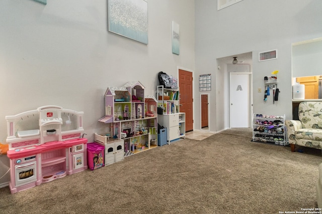 playroom with a towering ceiling and carpet floors