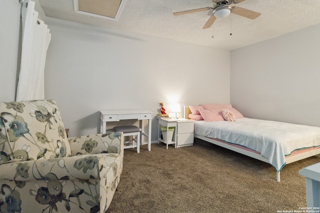 bedroom featuring ceiling fan, dark carpet, and a textured ceiling