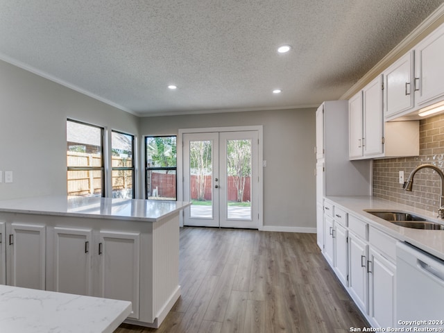 kitchen featuring white cabinets, white dishwasher, a wealth of natural light, and sink