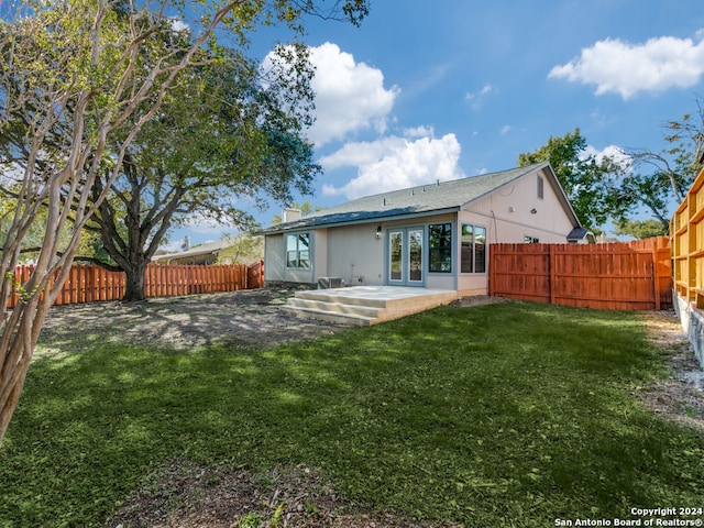 back of house featuring a patio and a lawn