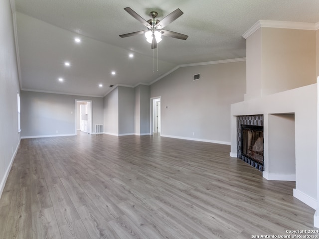 unfurnished living room with ceiling fan, light wood-type flooring, crown molding, and vaulted ceiling