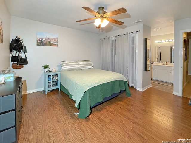 bedroom with ceiling fan, light hardwood / wood-style floors, and connected bathroom