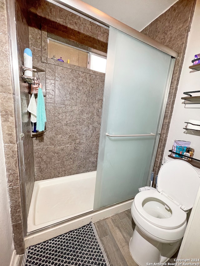 bathroom with an enclosed shower and toilet