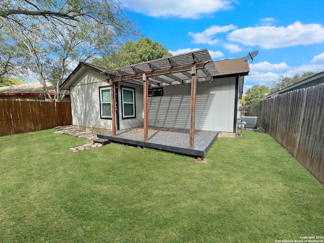 rear view of property with a yard, a pergola, cooling unit, and a wooden deck