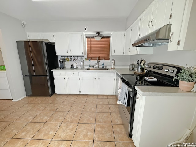 kitchen with appliances with stainless steel finishes, sink, light tile patterned floors, white cabinets, and washer / clothes dryer