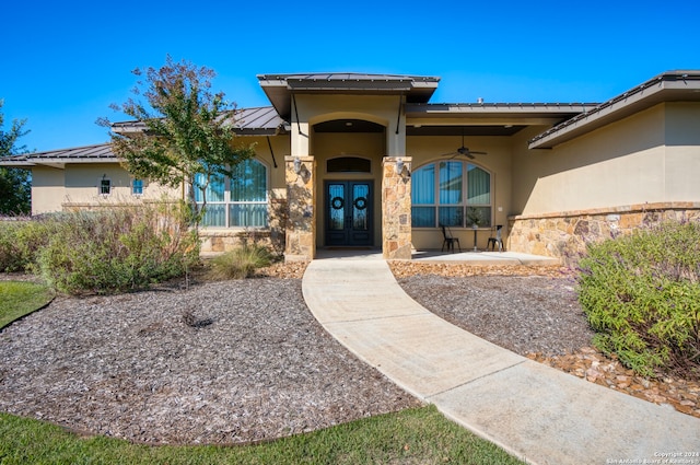 view of exterior entry featuring ceiling fan, a patio area, and french doors