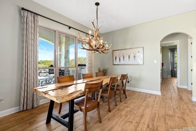 dining space with a chandelier and light hardwood / wood-style flooring