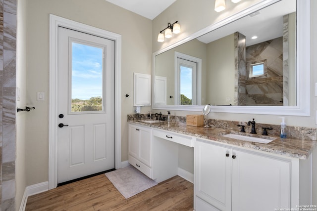 bathroom featuring vanity, wood-type flooring, and tiled shower