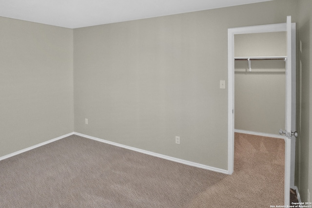 unfurnished bedroom featuring carpet, a spacious closet, and a closet