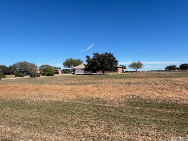 view of yard featuring a rural view and a garage