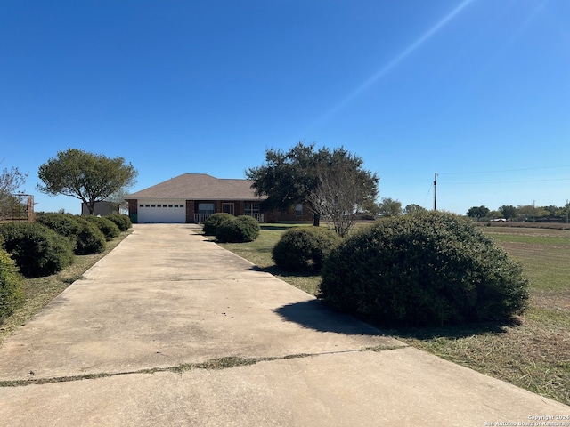 ranch-style house with a garage and a front lawn