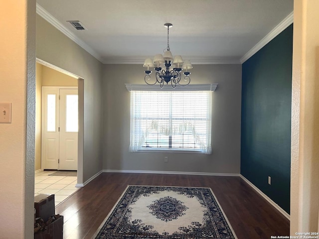 unfurnished dining area with wood-type flooring, ornamental molding, and a chandelier