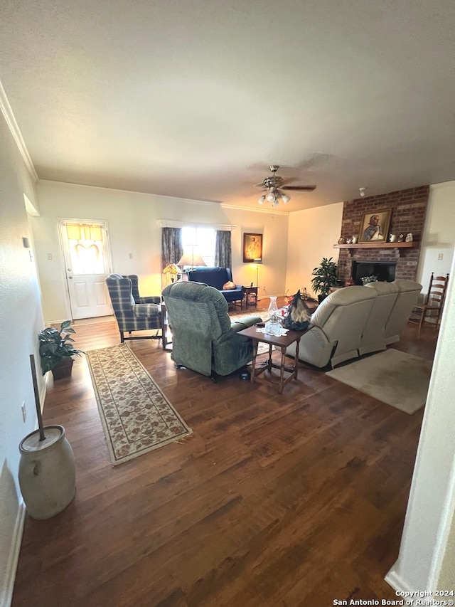 living room featuring ceiling fan, dark hardwood / wood-style flooring, and a brick fireplace