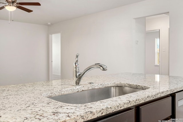 kitchen featuring light stone countertops, sink, and ceiling fan