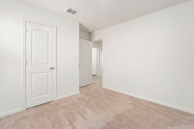 unfurnished bedroom featuring light carpet