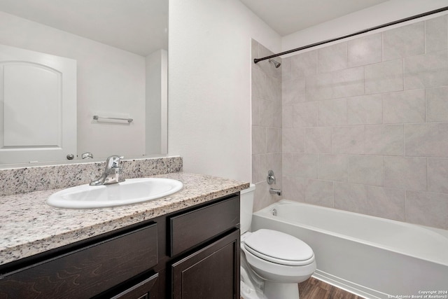 full bathroom with wood-type flooring, vanity, toilet, and tiled shower / bath