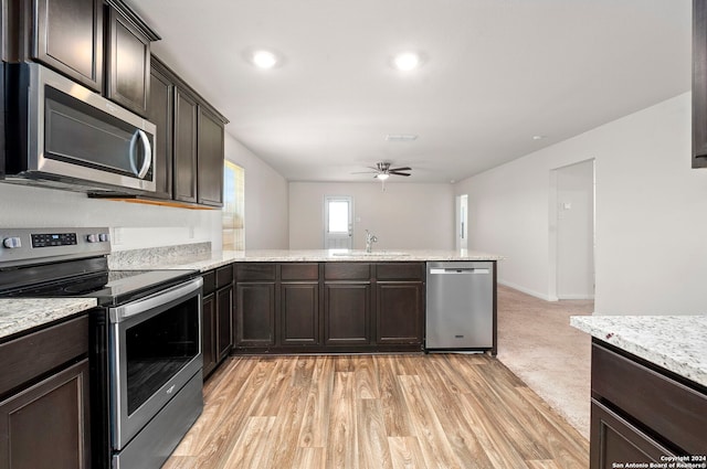 kitchen with ceiling fan, sink, stainless steel appliances, kitchen peninsula, and light hardwood / wood-style floors