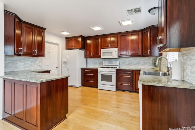 kitchen featuring backsplash, light hardwood / wood-style floors, white appliances, and sink