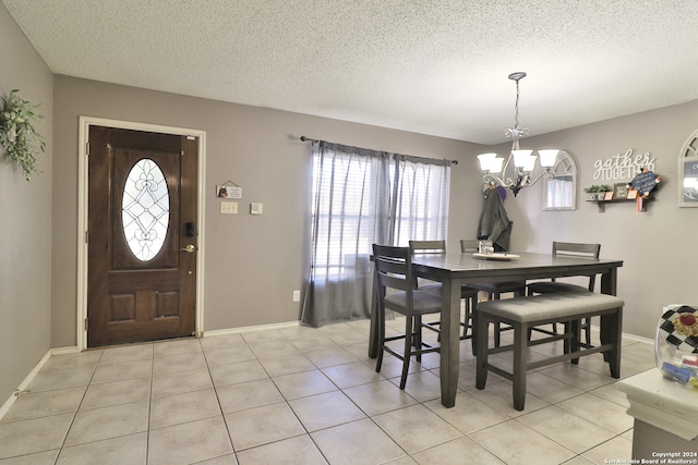 dining room with light tile patterned floors, a textured ceiling, and a chandelier