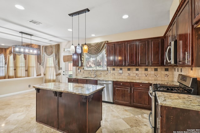 kitchen featuring a center island, decorative light fixtures, stainless steel appliances, and backsplash