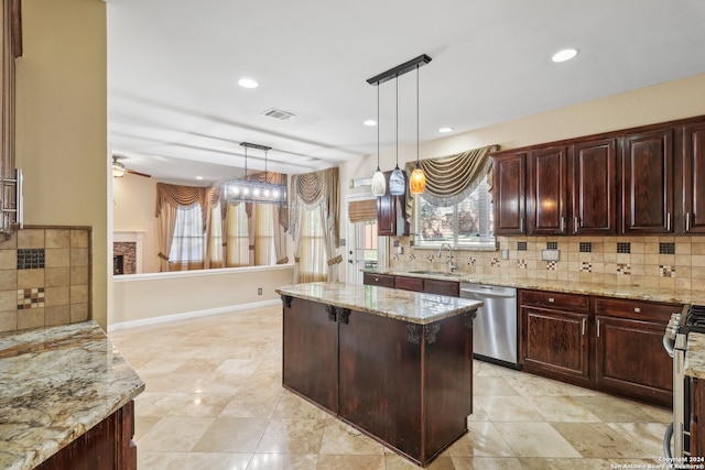 kitchen featuring pendant lighting, backsplash, stainless steel appliances, and a wealth of natural light