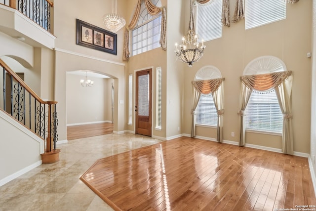 foyer entrance featuring hardwood / wood-style floors and a towering ceiling