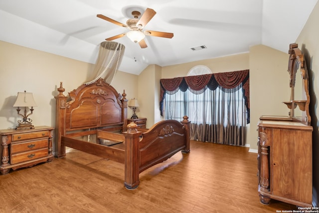 bedroom with ceiling fan, lofted ceiling, and light wood-type flooring