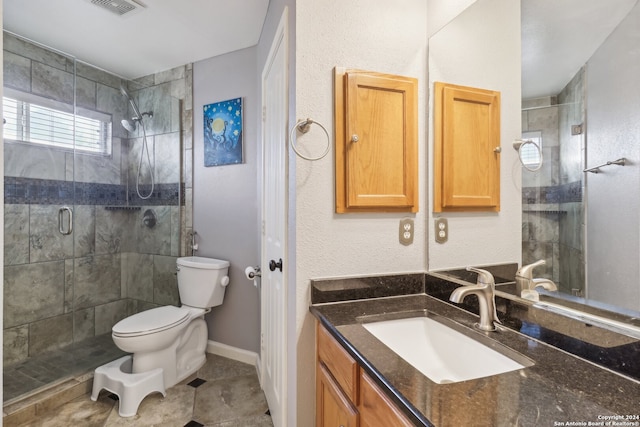 bathroom featuring tile patterned flooring, vanity, toilet, and a shower with door