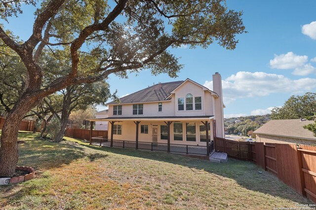 rear view of house featuring a yard