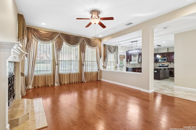 unfurnished living room featuring hardwood / wood-style floors and ceiling fan