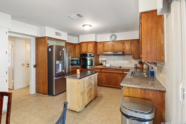 kitchen with backsplash, sink, black appliances, a center island, and light tile patterned flooring