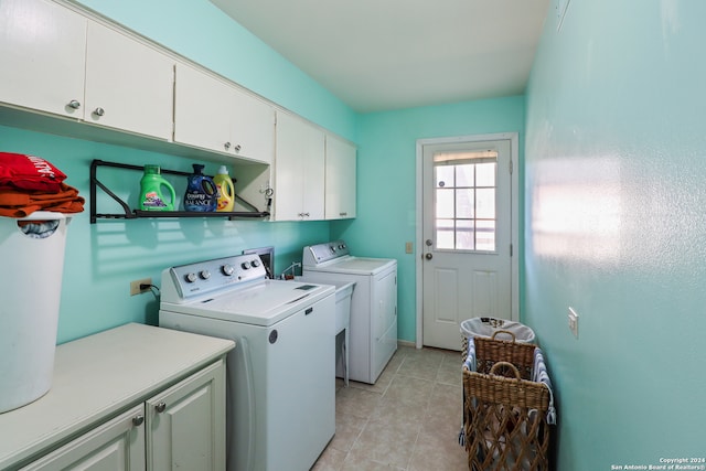 laundry room with cabinets, light tile patterned floors, and washer and clothes dryer