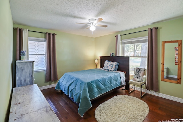 bedroom featuring ceiling fan, dark wood-type flooring, and a textured ceiling