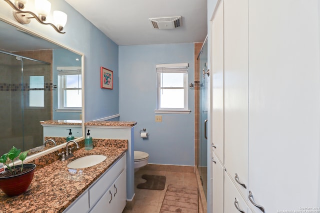 bathroom with a wealth of natural light, tile patterned flooring, an enclosed shower, and toilet