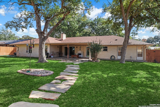 rear view of house featuring a yard and a patio