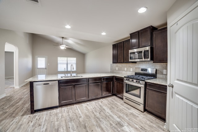 kitchen featuring kitchen peninsula, light wood-type flooring, stainless steel appliances, sink, and lofted ceiling