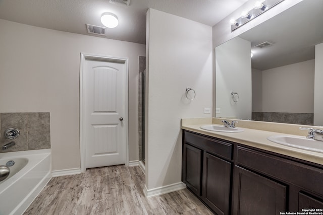 bathroom featuring hardwood / wood-style floors, vanity, and a tub to relax in